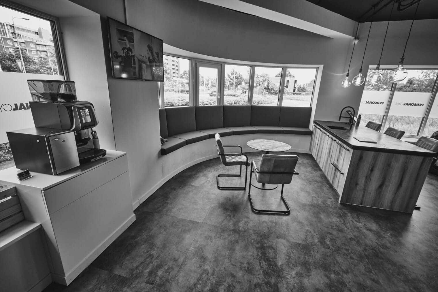 De lounge van PersonalGYM met koffiehoek en zithoek bij het raam
